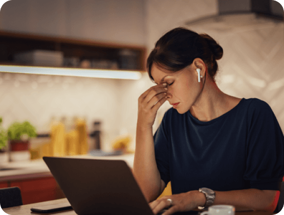 Frau die am Laptop arbeitet, zeigt ersschopfung bei ubersauerung