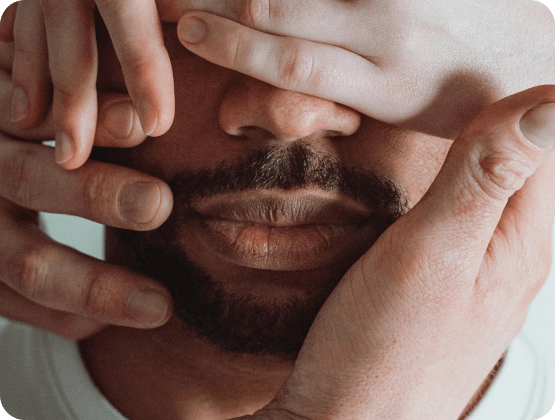 Mann mit Bart und Händen im Gesicht, Zeigt Einfluss von Testosteron auf Kinderwunsch