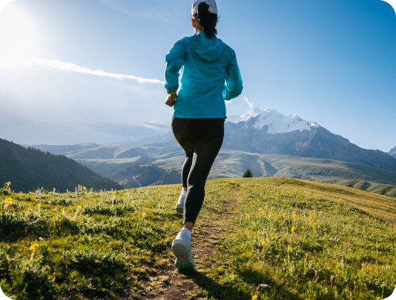 Woman running on a mountain trail with creatine