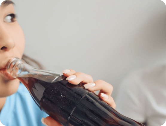 Frau trinkt Softdrink, zeigt zufuhr von Phosphaten